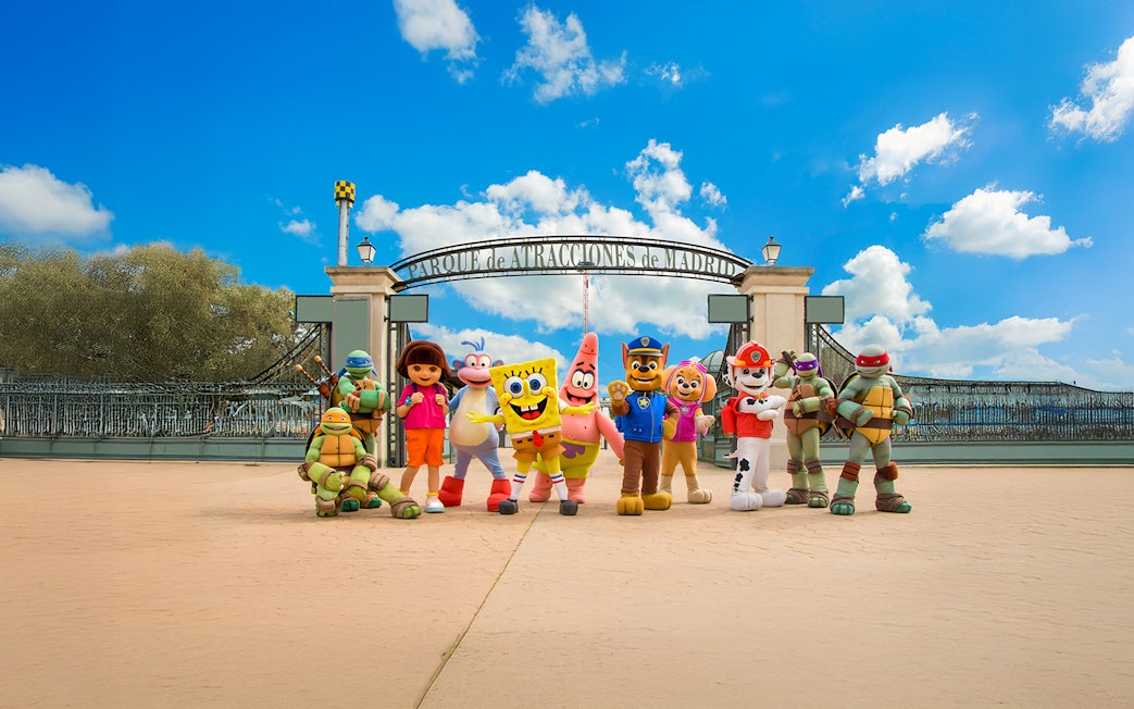 Visitors at Parque de Atracciones de Madrid entrance with character mascots.