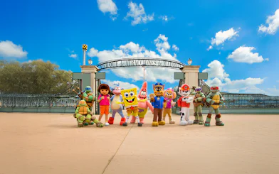 Visitors at Parque de Atracciones de Madrid entrance with character mascots.