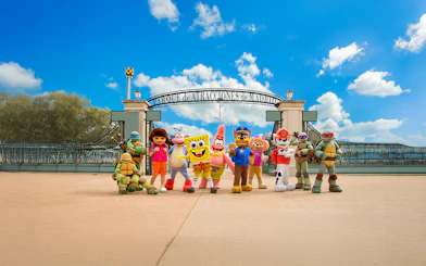 Visitors at Parque de Atracciones de Madrid entrance with character mascots.