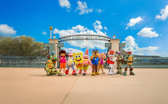 Visitors at Parque de Atracciones de Madrid entrance with character mascots.