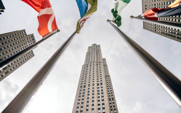 Looking up at skyscraper with flags, part of SUMMIT One Vanderbilt and walking tour.
