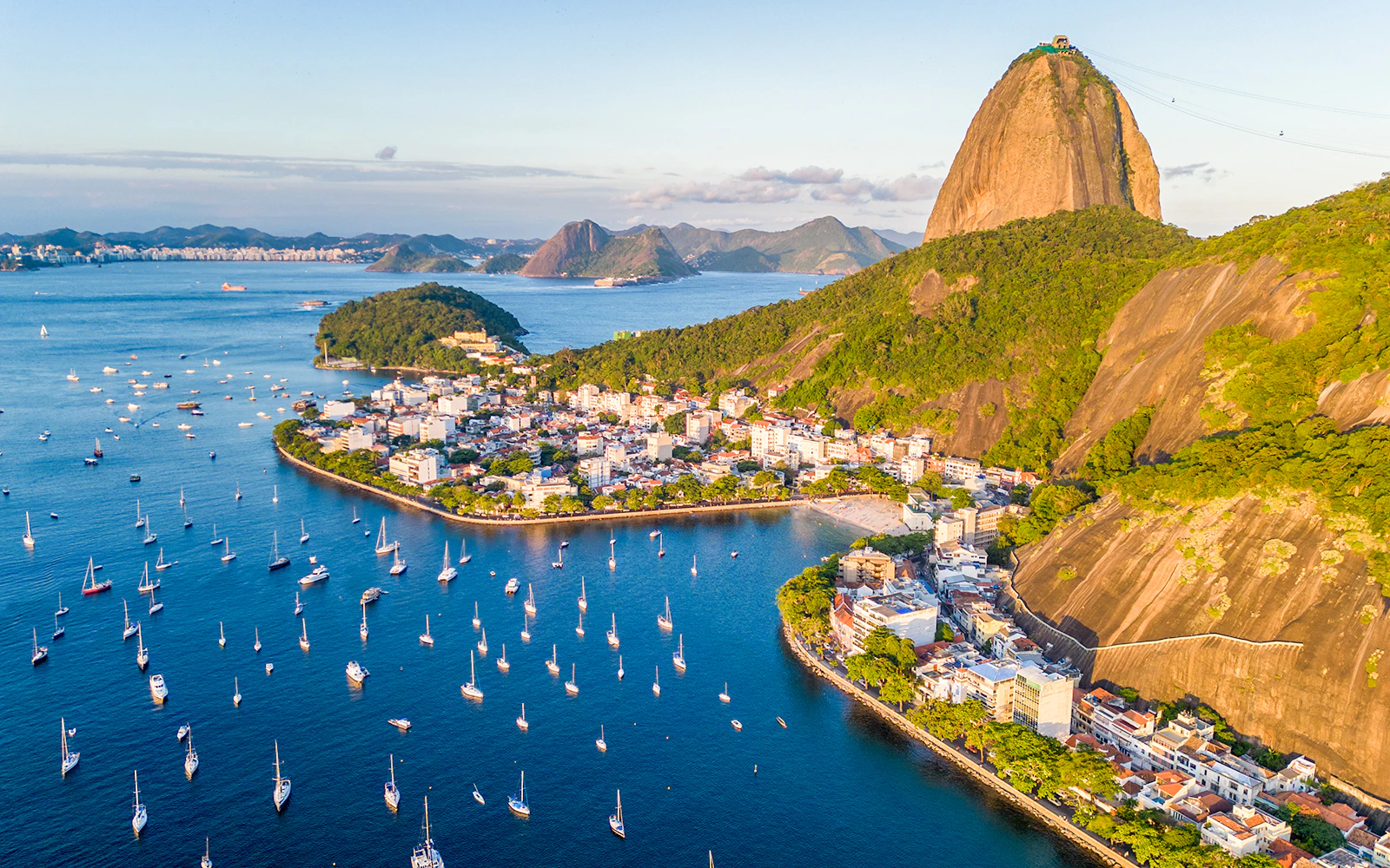 Aerial view of Urca neighborhood and Sugarloaf Mountain in Rio de Janeiro with boats in Guanabara Bay.
