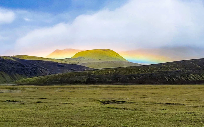 Landmannalaugar Highlands with rainbow over green hills, Iceland.