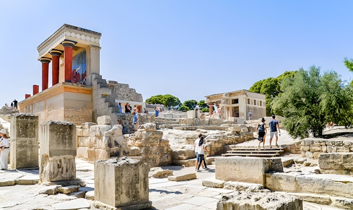 Visitors exploring the ancient ruins of the Palace of Knossos in Crete.
