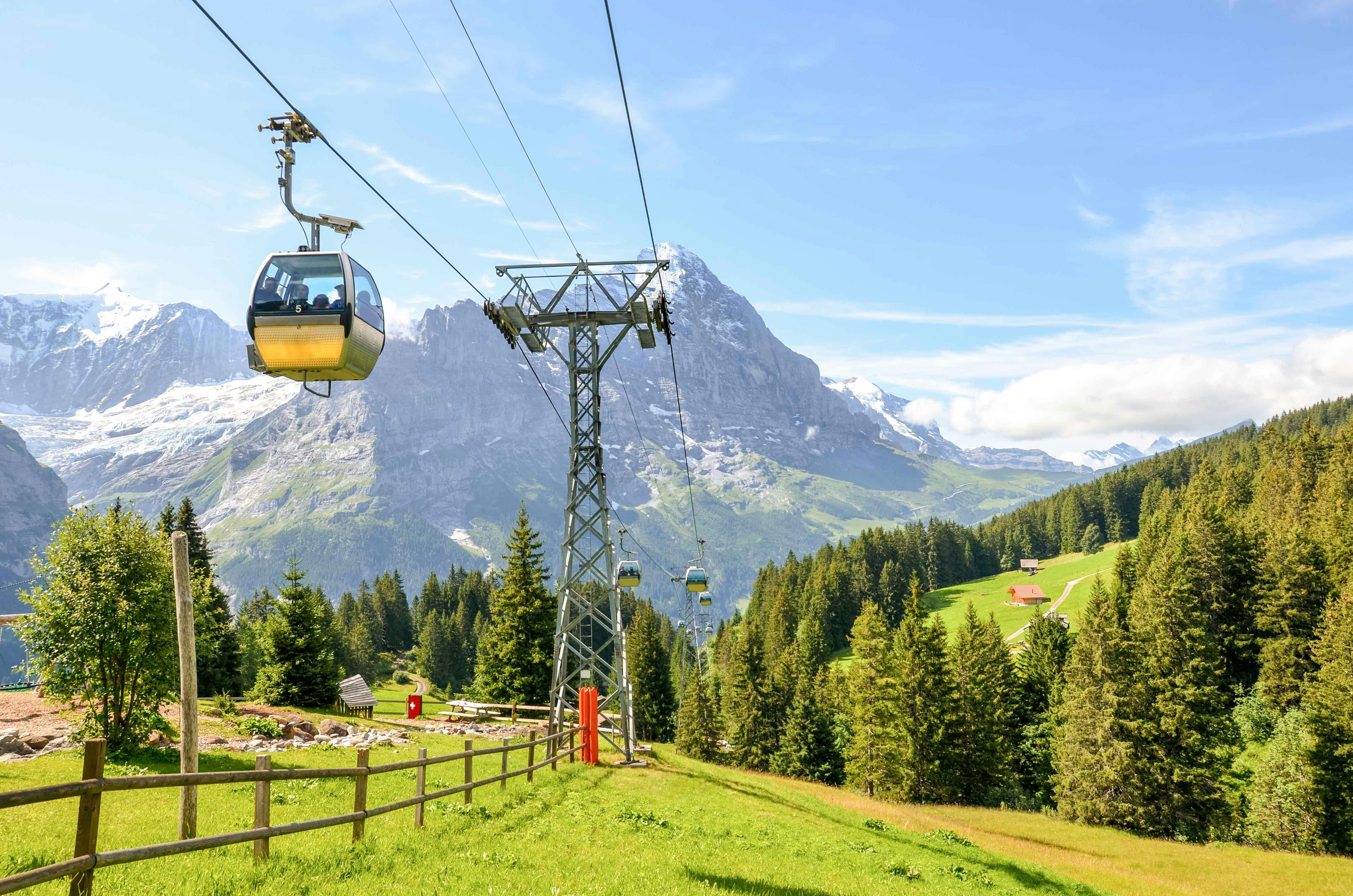 Grindelwald First cable car with mountain cart riders in Swiss Alps, Switzerland.