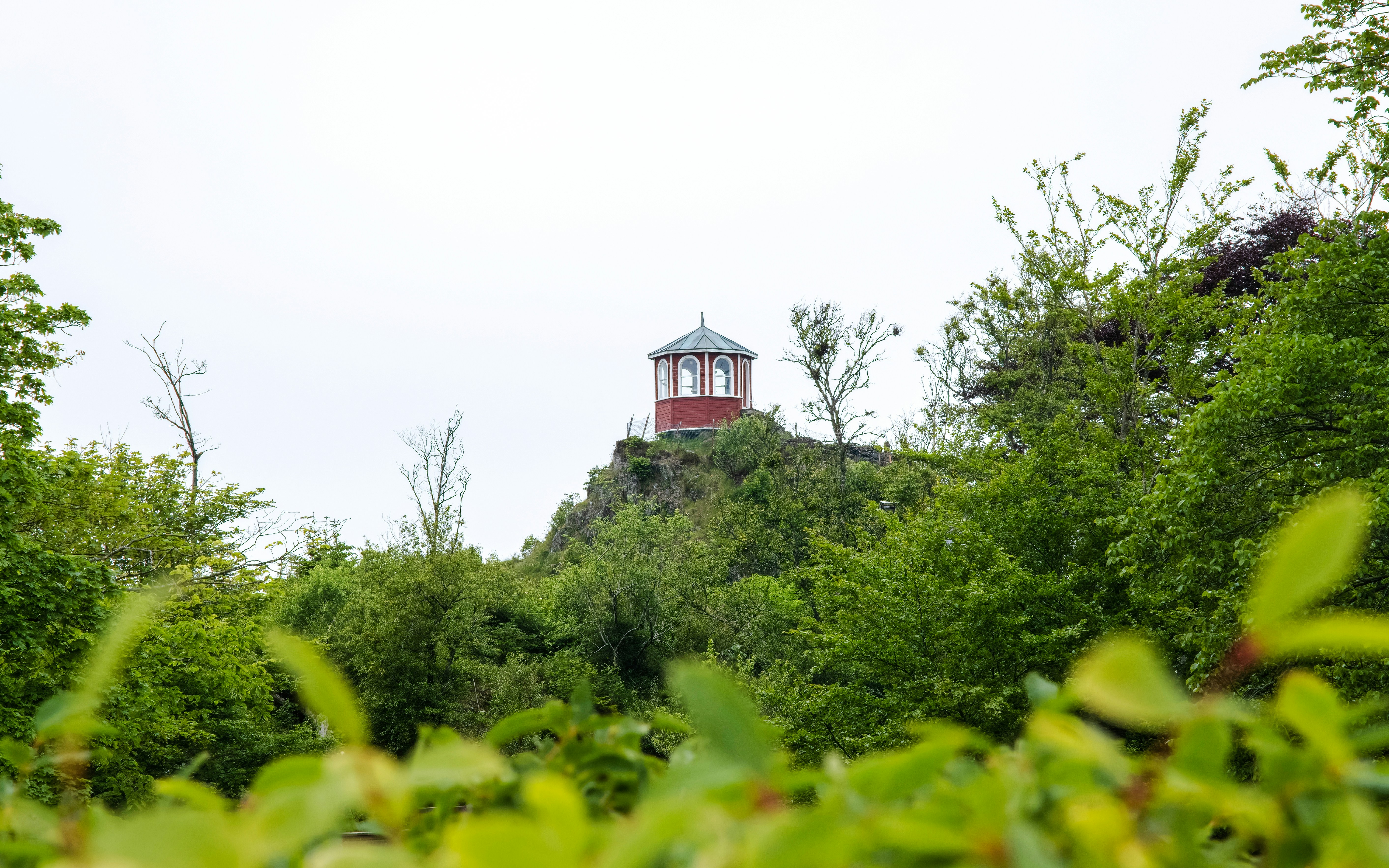 Red pavilion on a hill surrounded by greenery at Visnes Gruvemuseum, Haugesund.