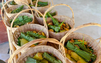 Wicker baskets filled with banana leaves and fruit at Krabi Elephant Local Project workshop.