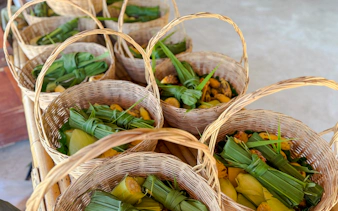 Wicker baskets filled with banana leaves and fruit at Krabi Elephant Local Project workshop.