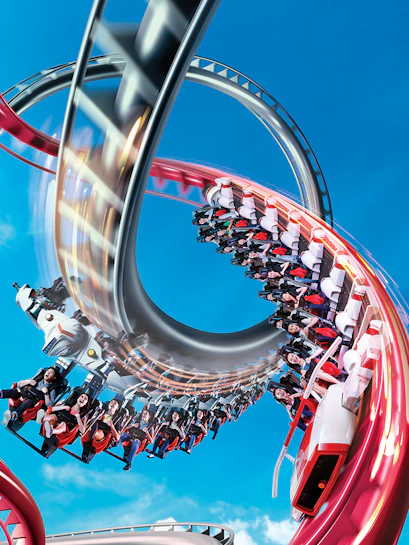 Rollercoaster loop at Universal Studios Singapore against blue sky.