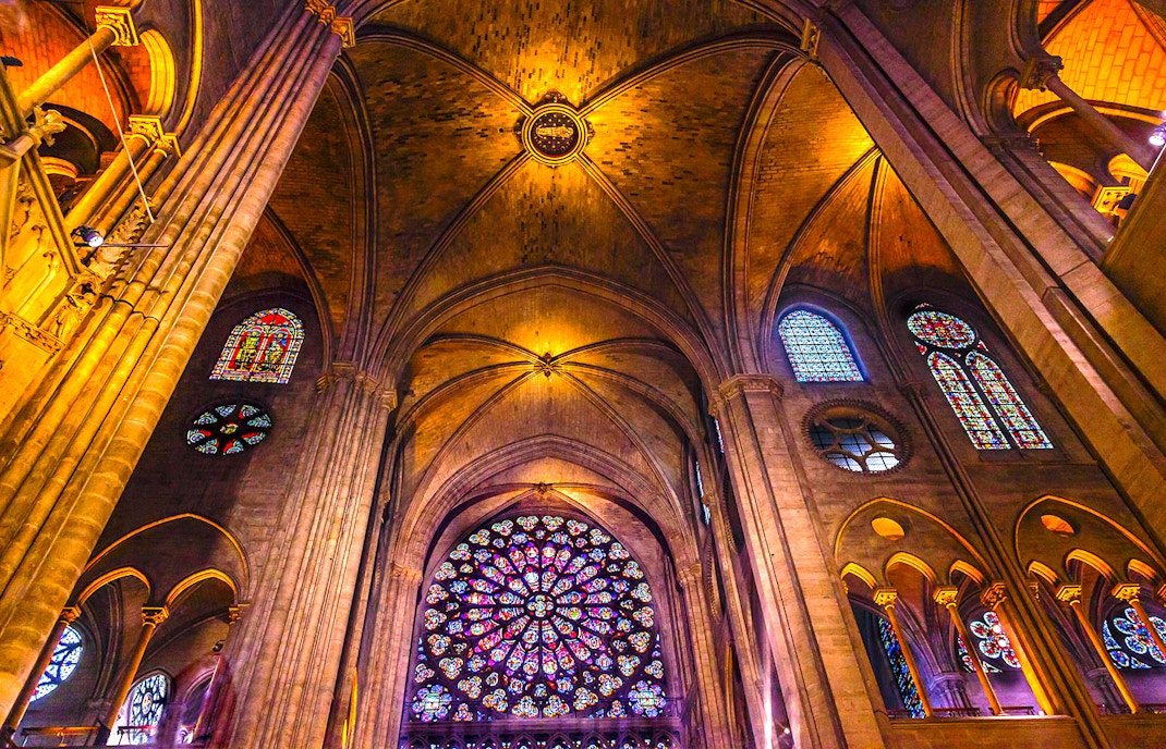 Notre-Dame Cathedral facade with tourists using audio guides in Paris.