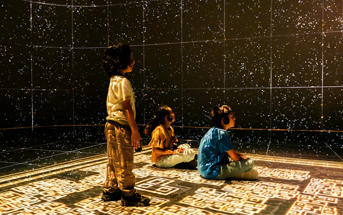 Children experiencing a starry projection at the London Timewalk Exhibition.