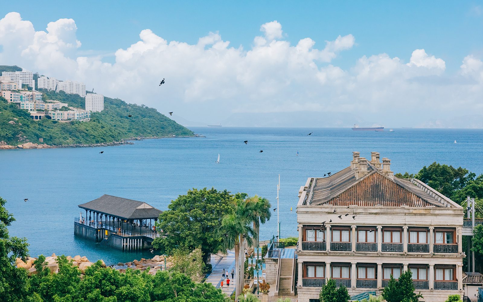 Seaside view with historic building and pier on Big Bus Hop-On Hop-Off Tour route.