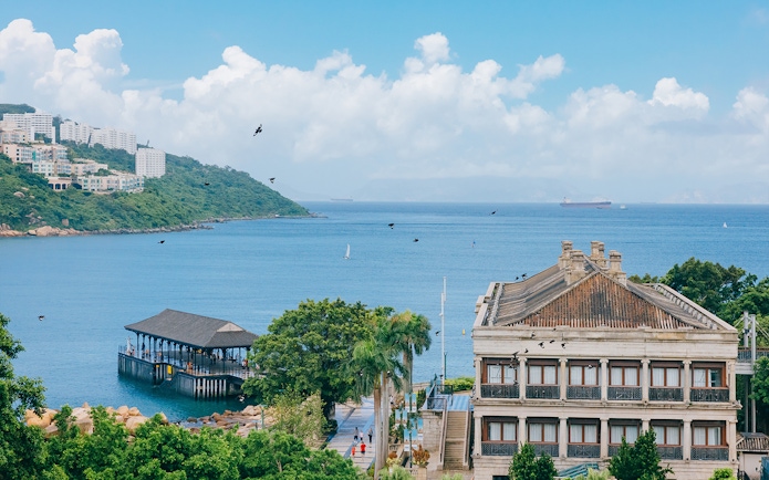 Seaside view with historic building and pier on Big Bus Hop-On Hop-Off Tour route.