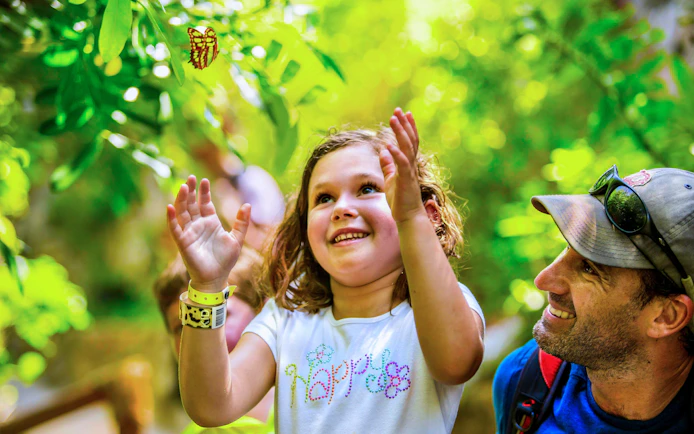Child enjoying butterfly exhibit at Xcaret Park.