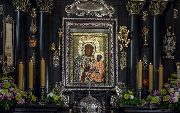 Jasna Gora's Black Madonna icon surrounded by ornate decorations and candles in Czestochowa, Poland.