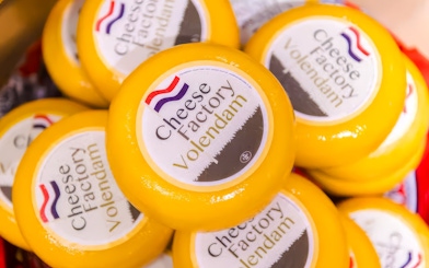 Cheese wheels labeled "Cheese Factory Volendam" in Volendam tasting tour.