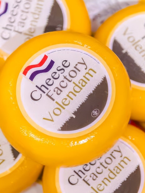 Cheese wheels labeled "Cheese Factory Volendam" in Volendam tasting tour.