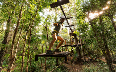 Adventurer crossing a rope bridge in Cancun Extreme Adventuring Park.