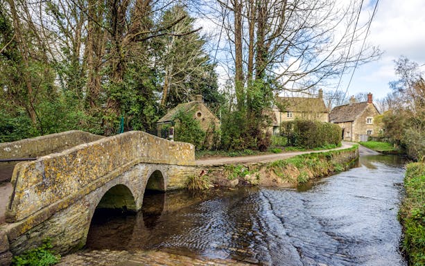 Stone bridge over a stream in the historic village of Lacock, Wiltshire, England.