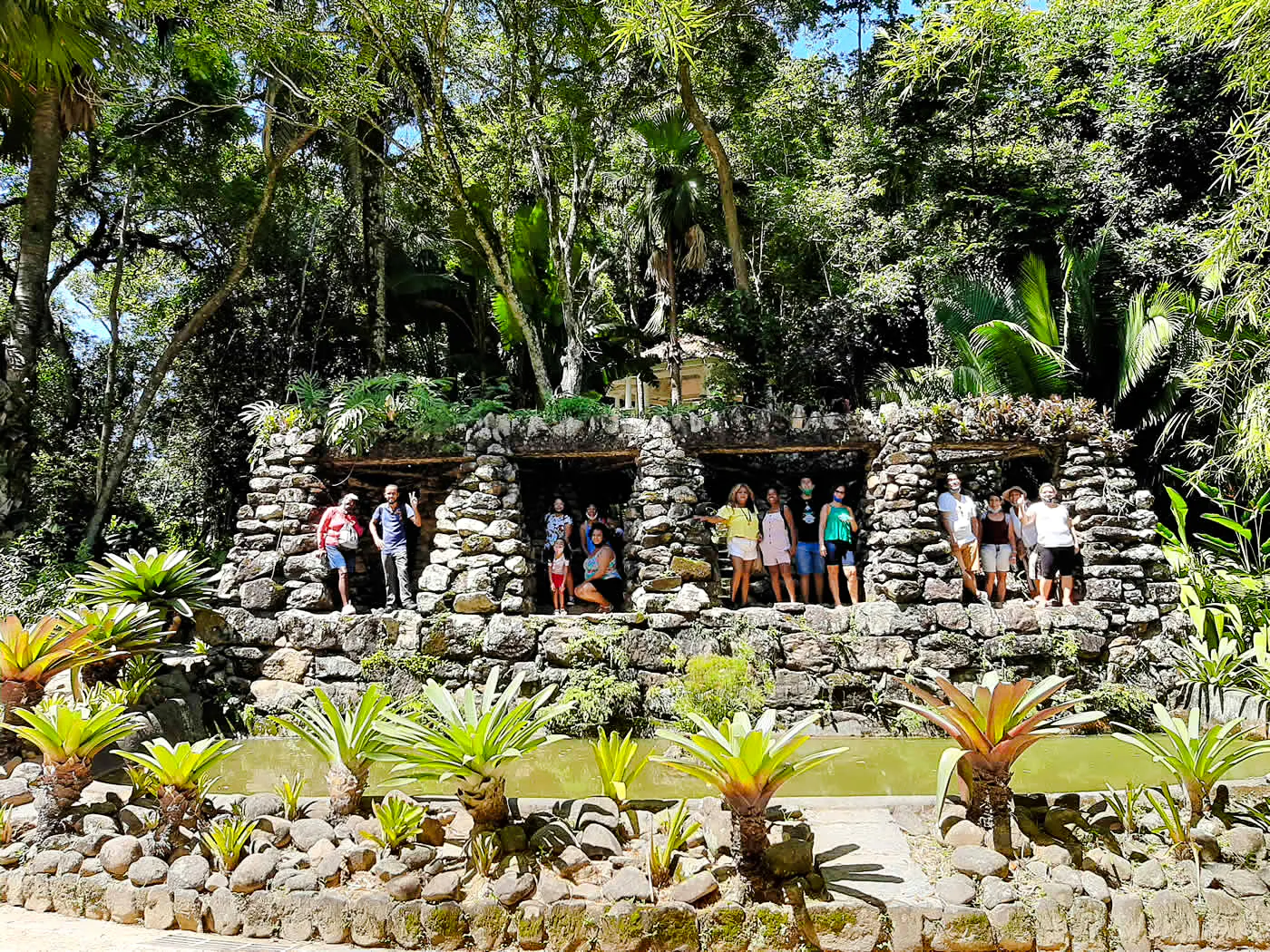 Visitors exploring stone structures in the lush Tijuca Forest, Rio de Janeiro.
