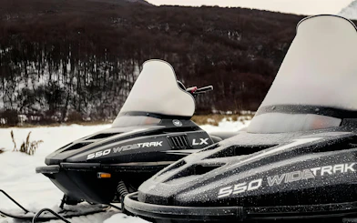 Snowmobiles on a snowy landscape in Ushuaia for a full day snow experience.