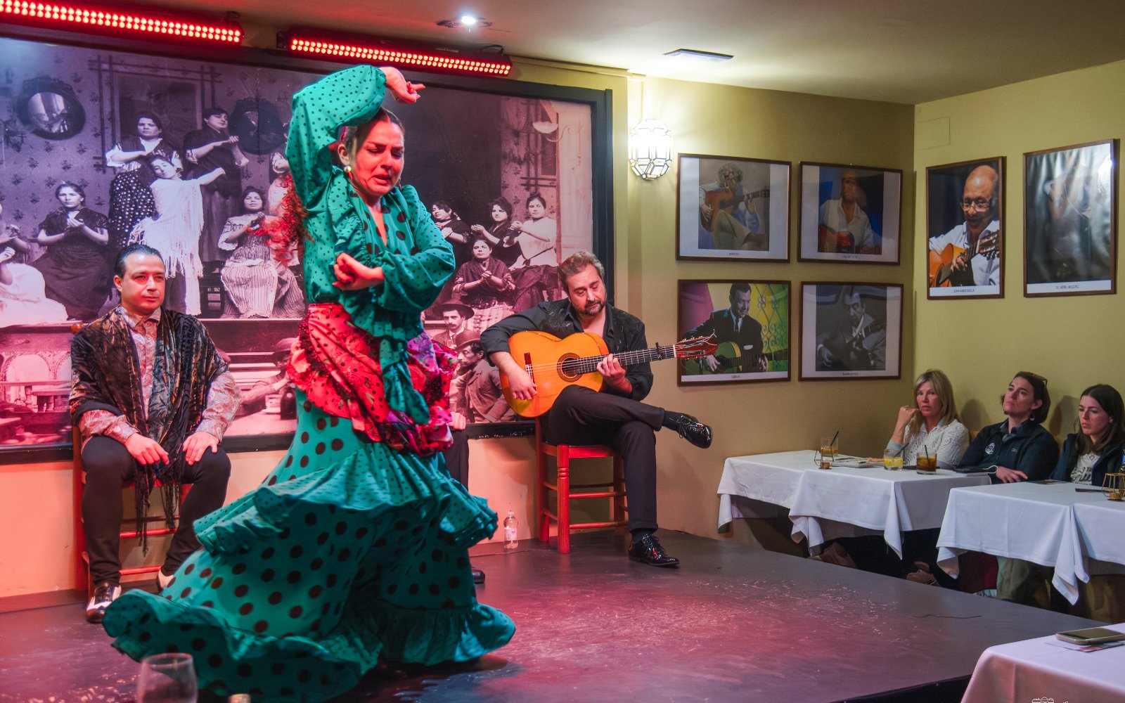 Flamenco dancers performing at Tablao La Cantaora, Seville with guitarist and audience.