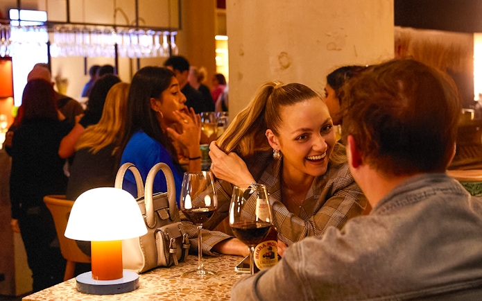 People enjoying drinks and conversation at a lively bar.