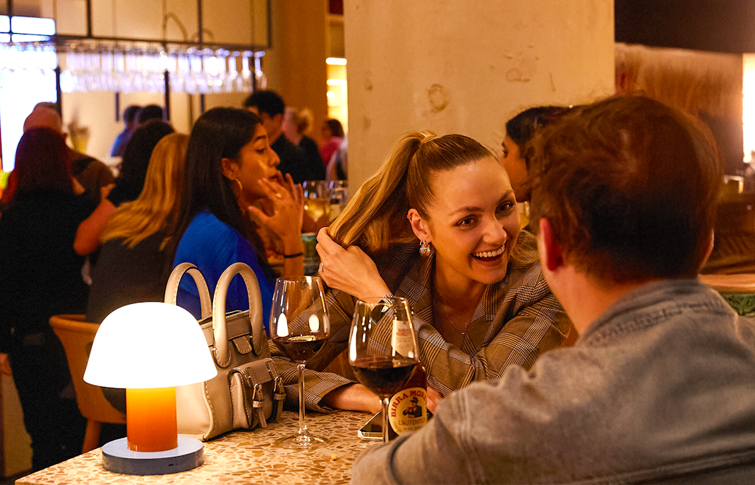 People enjoying drinks at Frameless Lates bar in London.
