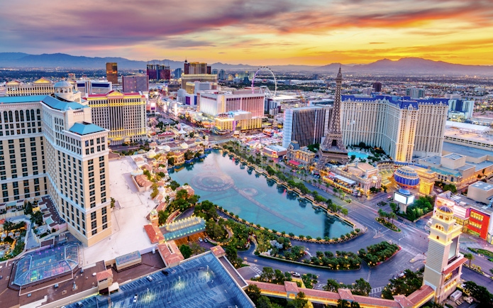 Las Vegas skyline at dusk with hotels and replica Eiffel Tower, Nevada, USA.