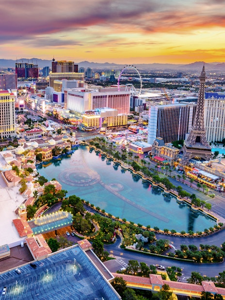 Las Vegas skyline at dusk with hotels and replica Eiffel Tower, Nevada, USA.