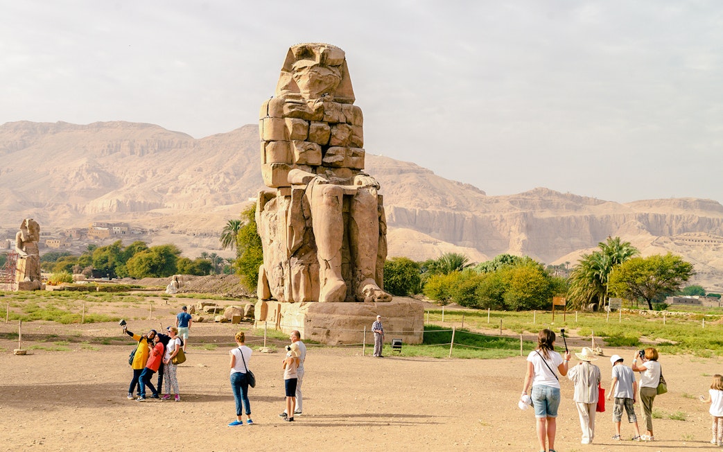 Tourists exploring the Colossi of Memnon near Luxor Temple, Egypt.