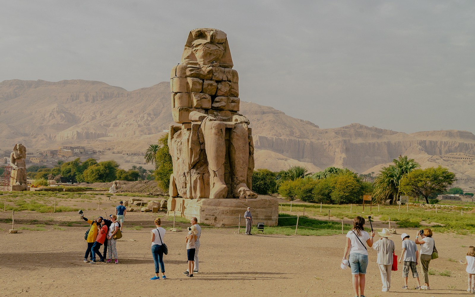 Tourists exploring the Colossi of Memnon near Luxor Temple, Egypt.