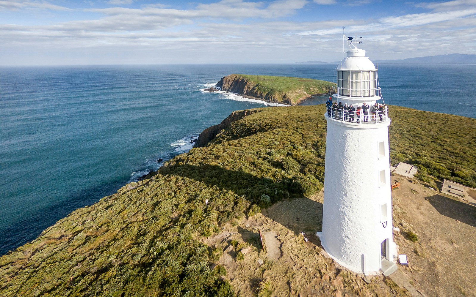 Cape Bruny Lighthouse with visitors exploring the Historic Lighthouse Museum on a guided tour.