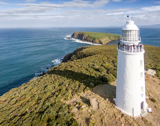 Cape Bruny Lighthouse with visitors exploring the Historic Lighthouse Museum on a guided tour.