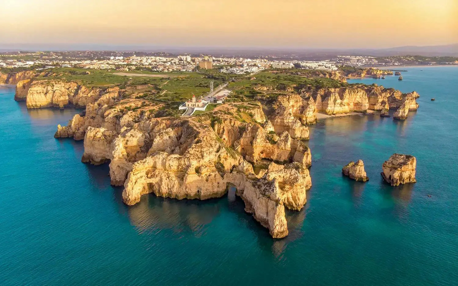 Algarve coastline with cliffs and ocean view during sunset on a sailing tour from Vilamoura.