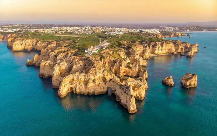 Algarve coastline with cliffs and ocean view during sunset on a sailing tour from Vilamoura.