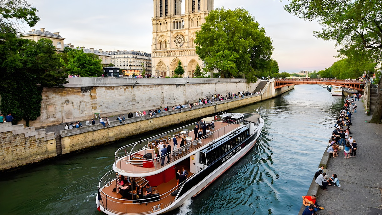 Seine River cruise boat, Paris, with passengers enjoying macaron tasting.