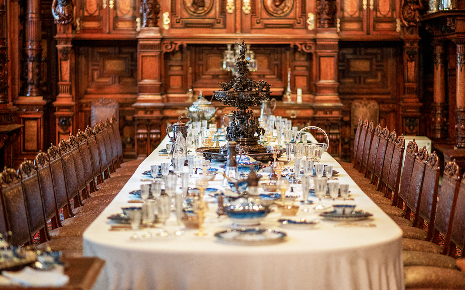 Dining table set with ornate decor inside Peles Castle, Romania.