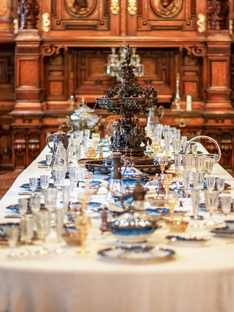 Dining table set with ornate decor inside Peles Castle, Romania.