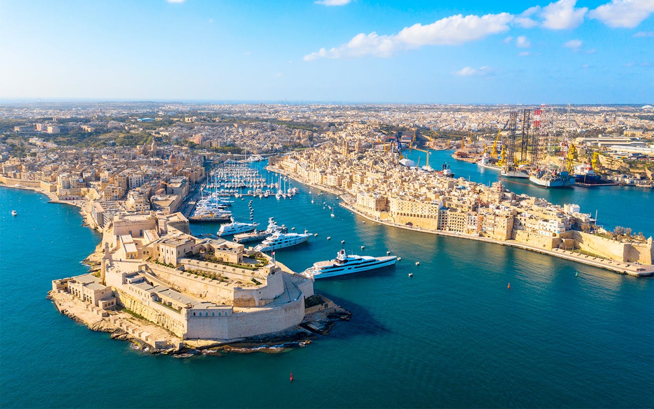 Aerial view of Malta's historic Three Cities with harbors and yachts.