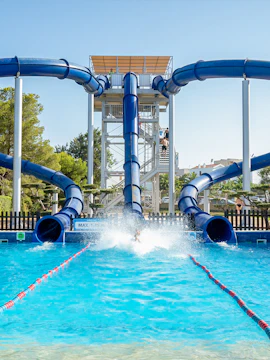 Water slide at Aquopolis Costa Dorada, Spain with person splashing into pool.