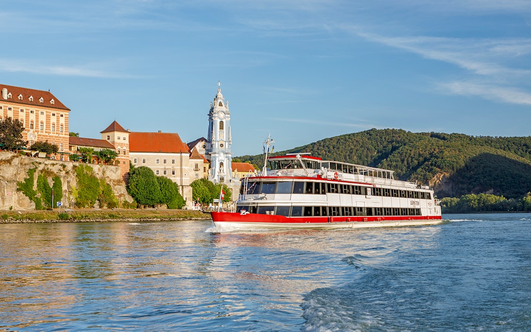 River cruise boat on the Danube near Dürnstein Abbey, Wachau Valley, Austria.