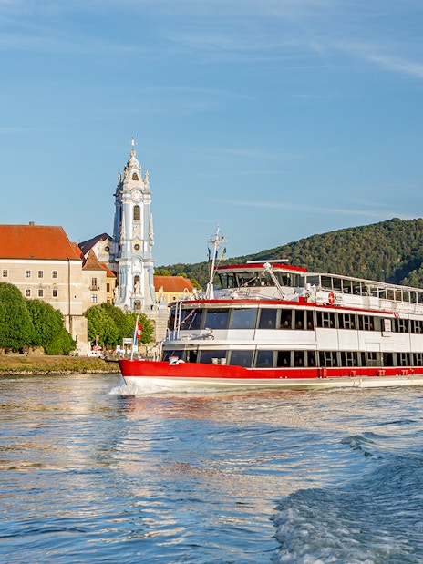 River cruise boat on the Danube near Dürnstein Abbey, Wachau Valley, Austria.