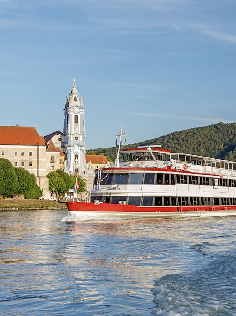 River cruise boat on the Danube near Dürnstein Abbey, Wachau Valley, Austria.