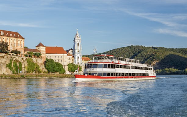 River cruise boat on the Danube near Dürnstein Abbey, Wachau Valley, Austria.