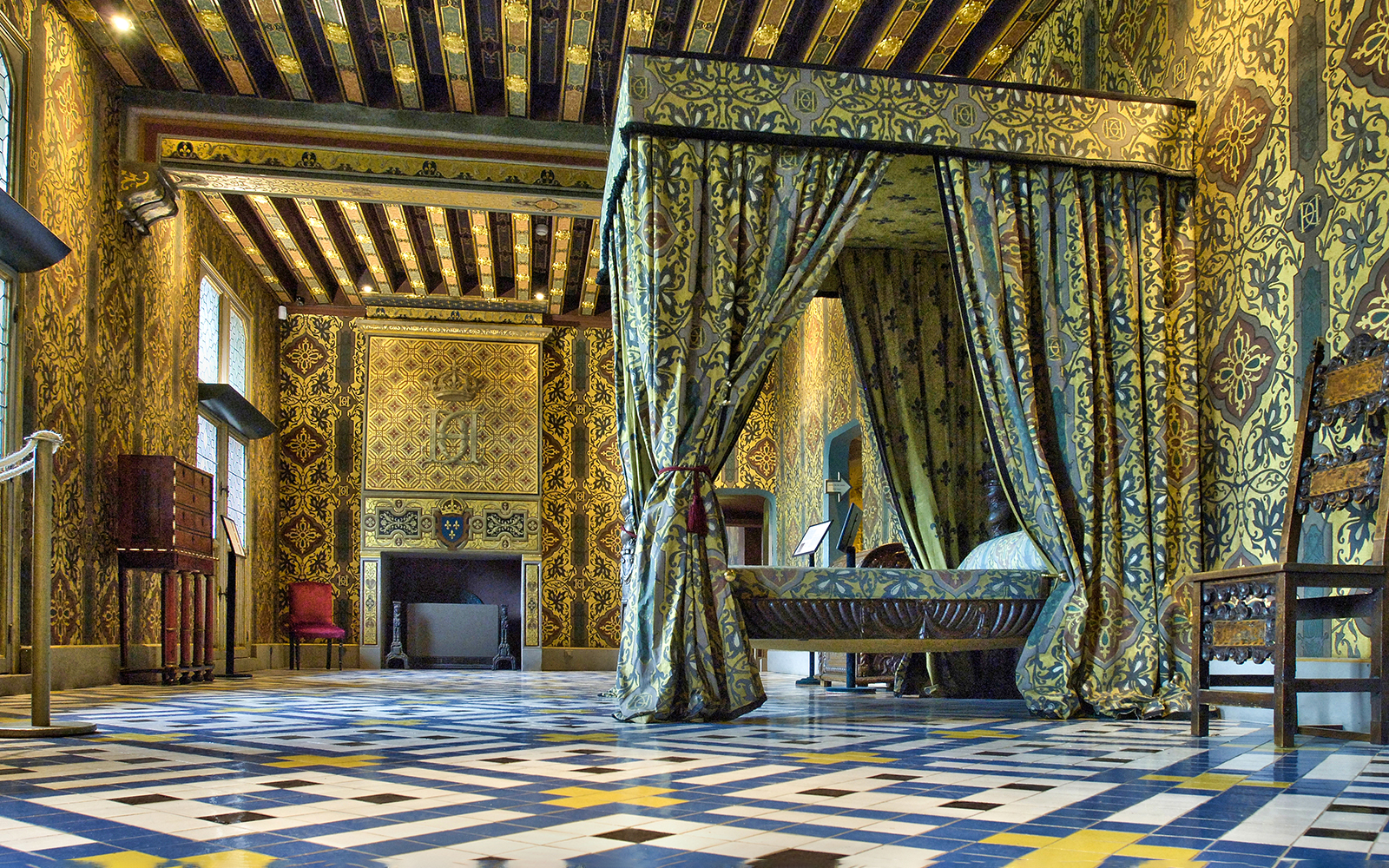 Royal Blois Castle interior with ornate bed and patterned walls.