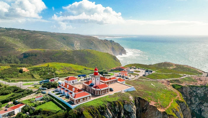 Cape Roca lighthouse on rugged cliff edge, Cabo da Roca, Portugal, Europe's westernmost point.