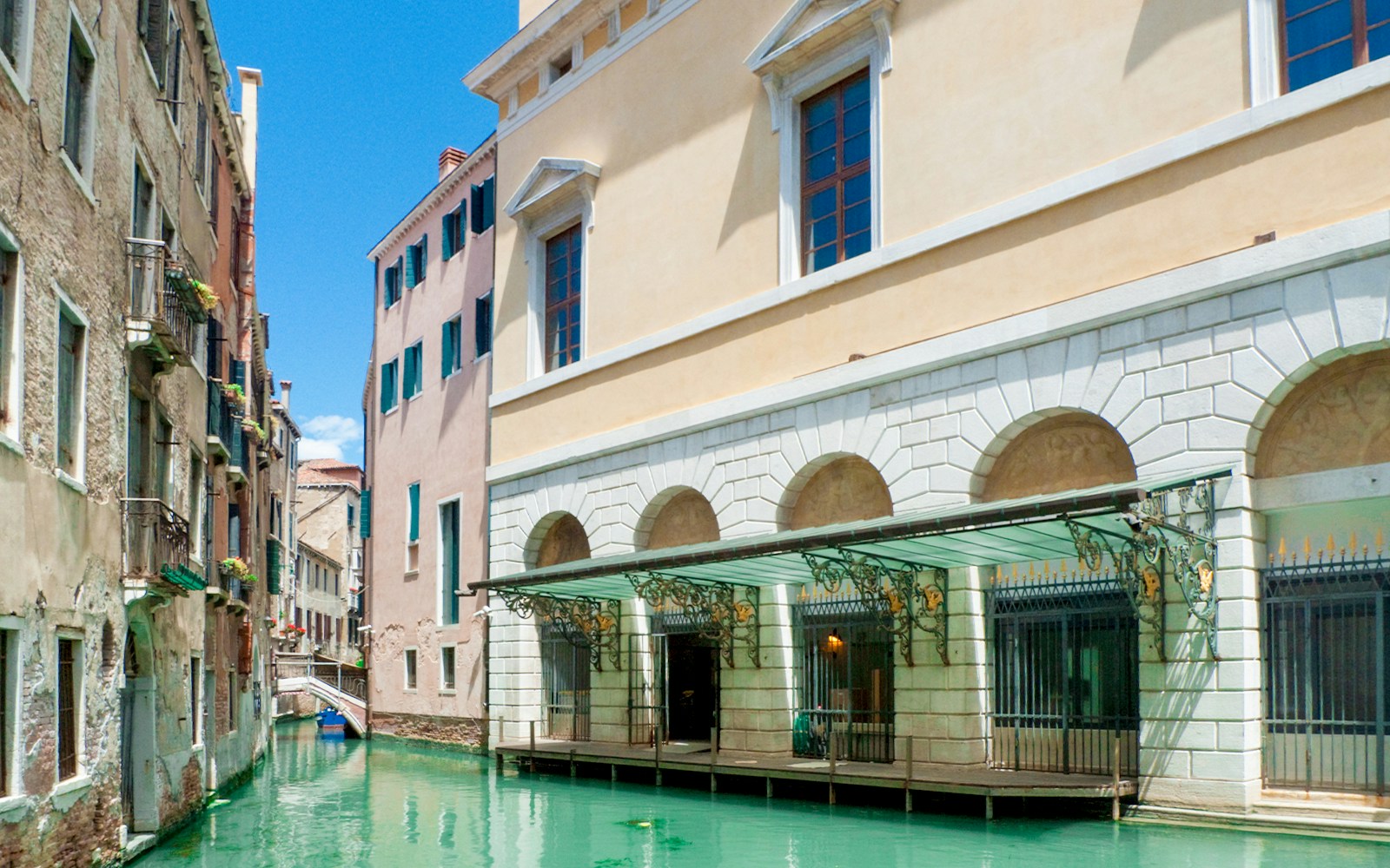 Canal view near Teatro La Fenice, Venice, with historic buildings and gondola passage.