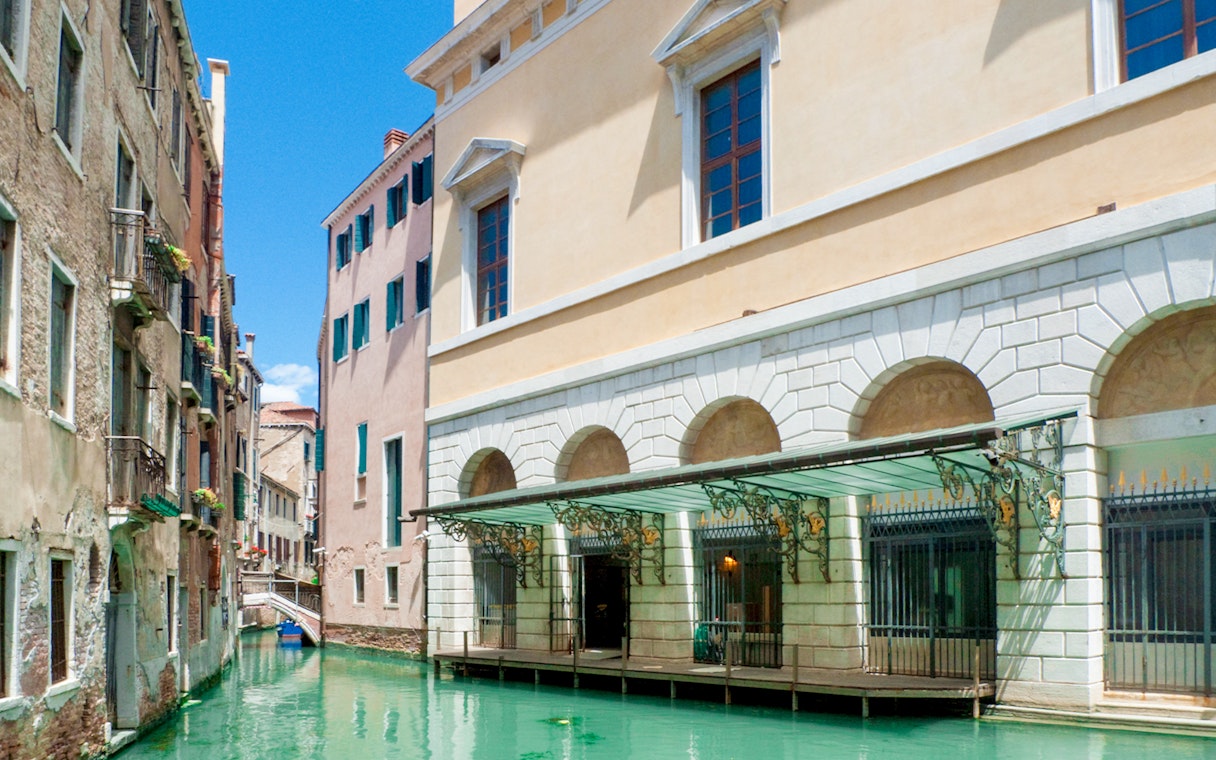 Canal view near Teatro La Fenice, Venice, with historic buildings and gondola passage.