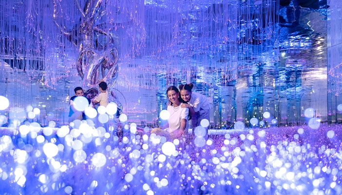 Visitors exploring interactive light installations at AYA Universe, Dubai.